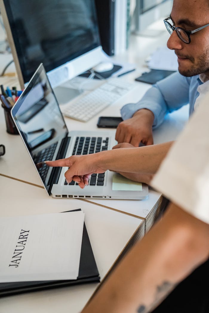 Manager pointing to an error on the laptop screen